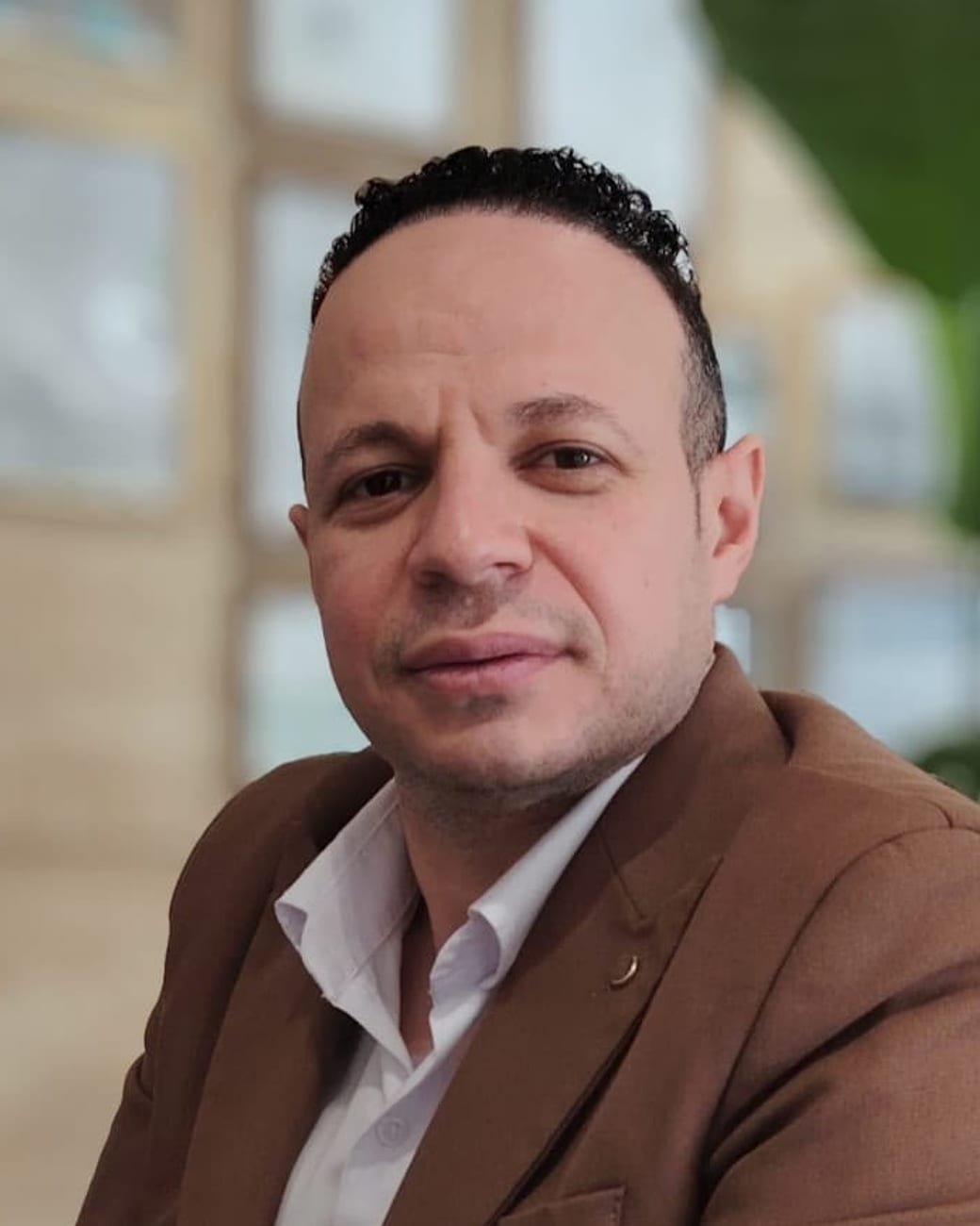 صورة محمد صلاح، المدير العام لمجموعة فنادق أبيات الشرق، بسترة بنية وقميص أبيض